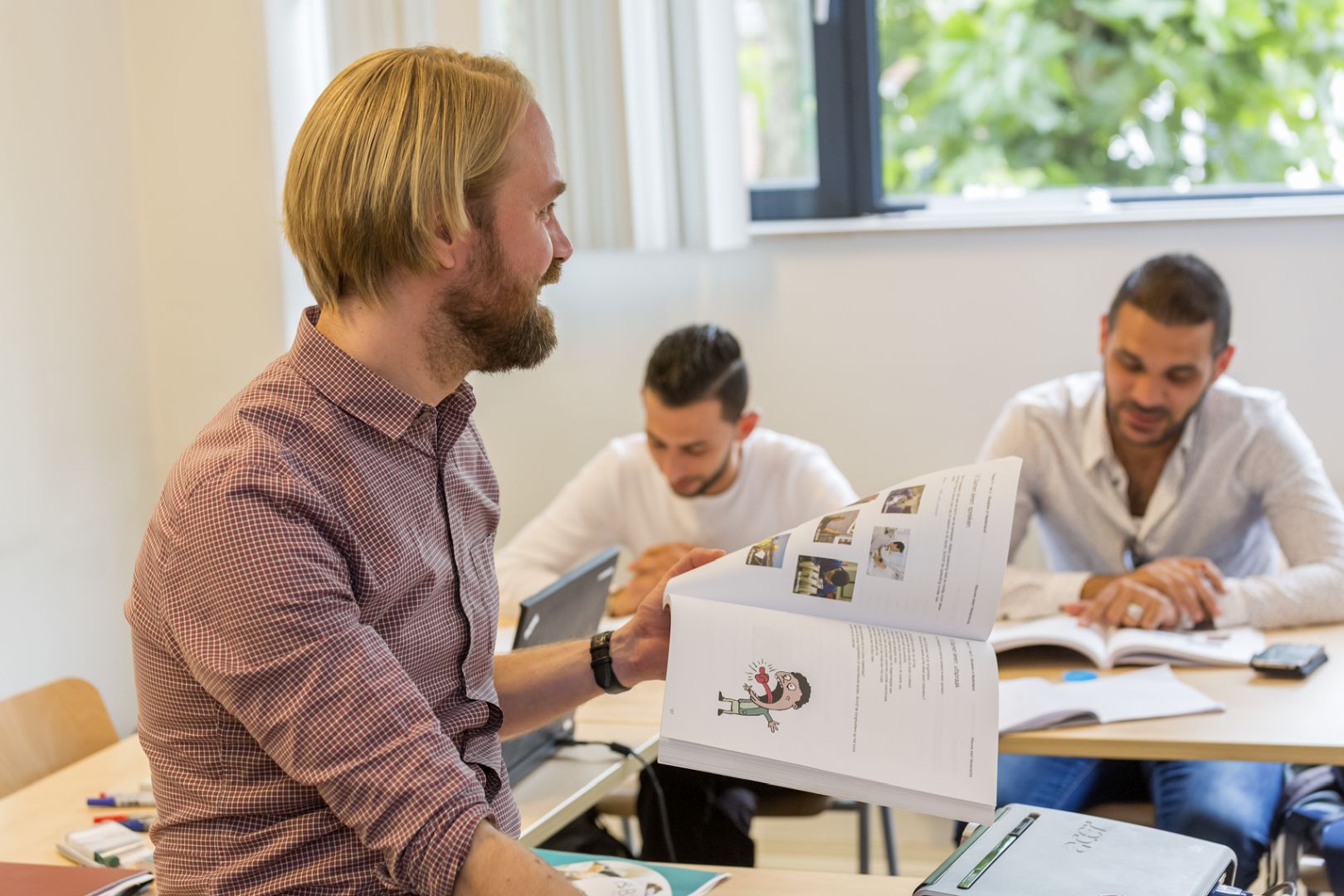 Bisbee docent geeft NT2-les met cursisten aanwezig