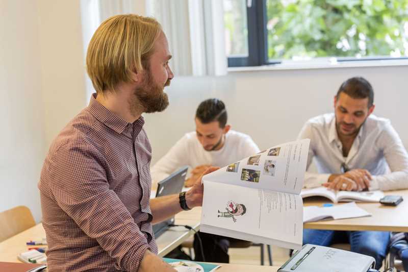 Bisbee docent geeft NT2-les met cursisten aanwezig